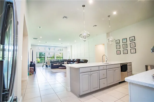 a large white kitchen with a large window and stainless steel appliances