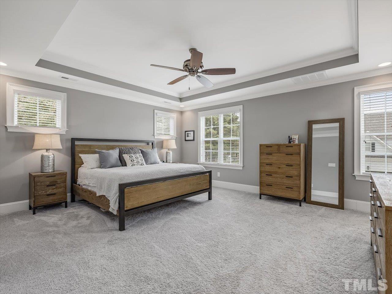 6427 Rosny Road Raleigh, NC 27613 - Photo 32 of 53 a bedroom with a bed and a chandelier