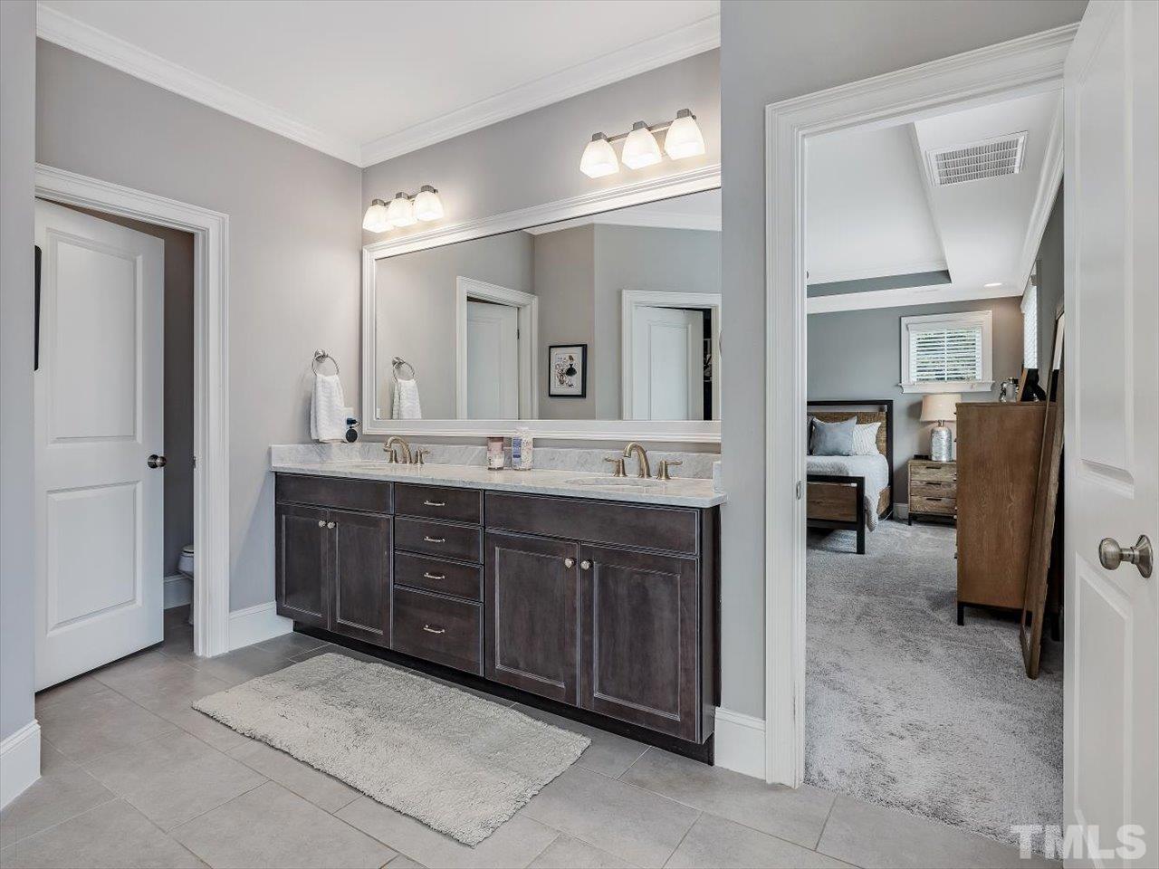 6427 Rosny Road Raleigh, NC 27613 - Photo 35 of 53 a spacious bathroom with a double vanity sink and a mirror