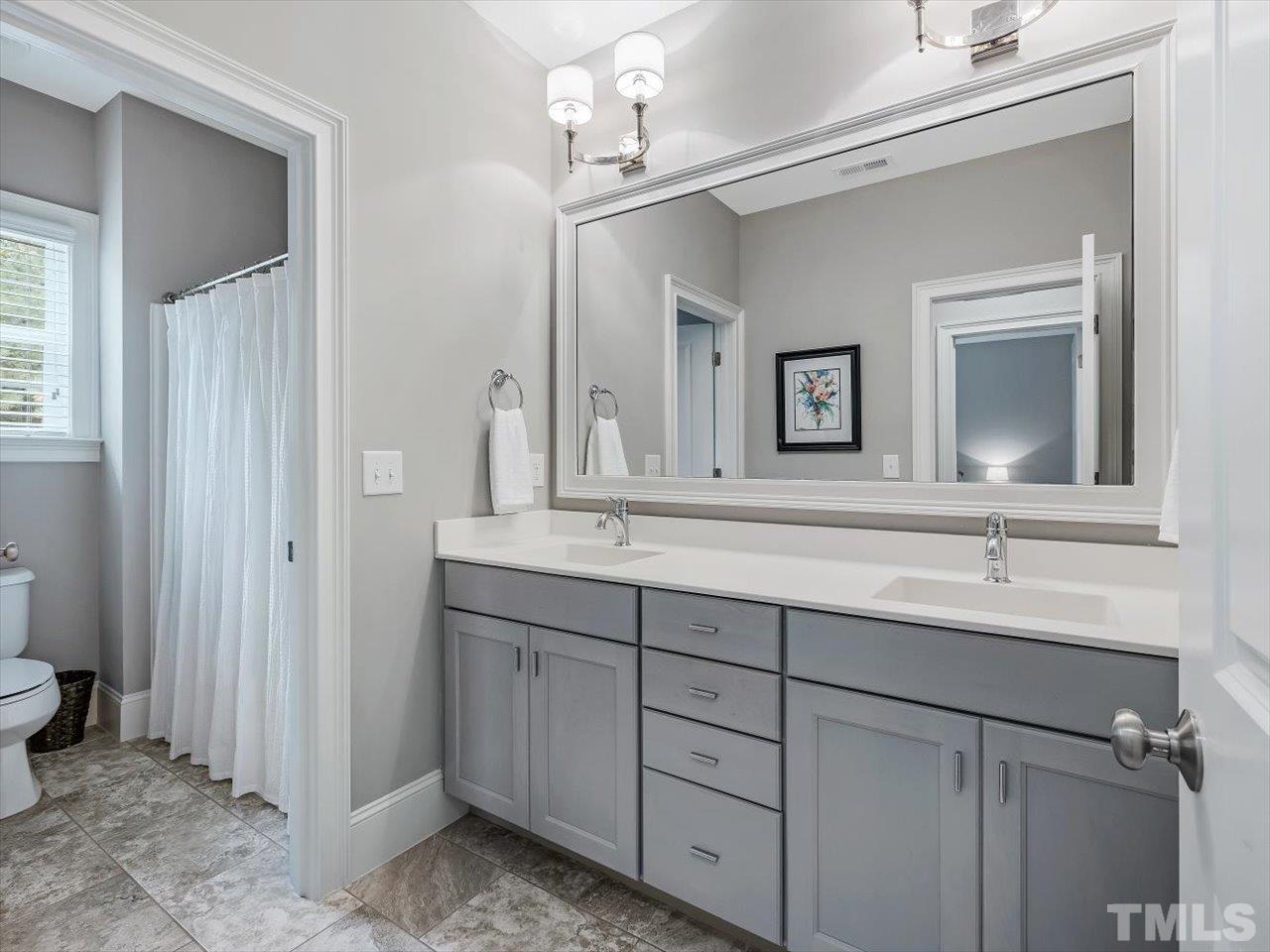 6427 Rosny Road Raleigh, NC 27613 - Photo 41 of 53 a bathroom with a double vanity sink and a mirror