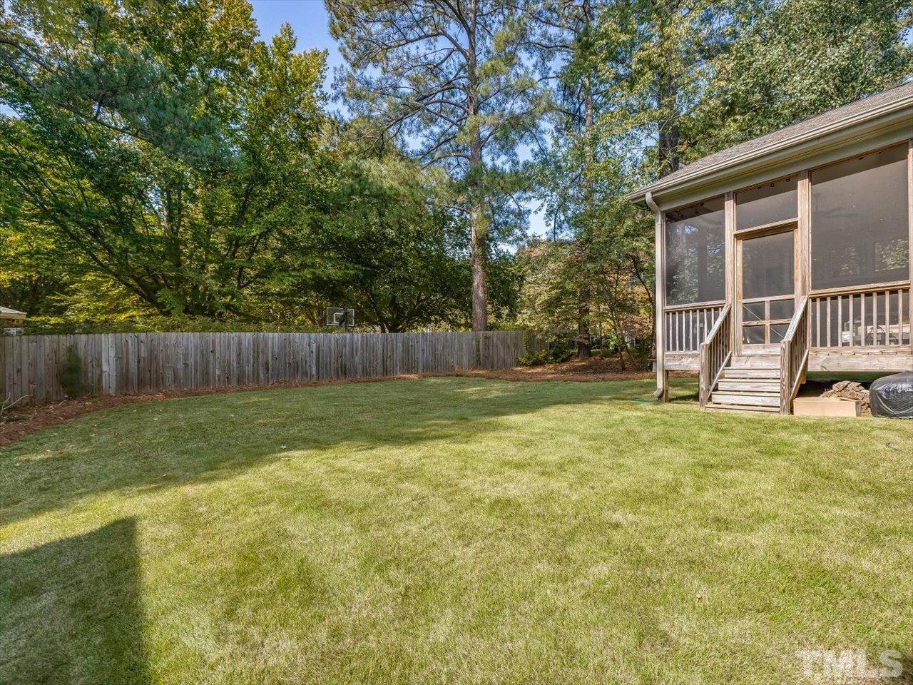 6427 Rosny Road Raleigh, NC 27613 - Photo 51 of 53 a view of a backyard with table and chairs and wooden fence