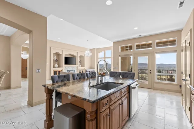 a kitchen with granite countertop a sink and a refrigerator