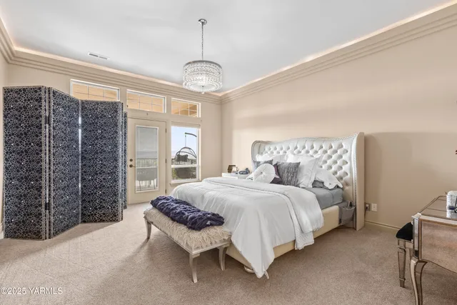 a spacious bedroom with a bed and a chandelier