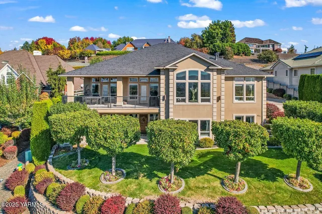 a front view of a house with a yard and potted plants