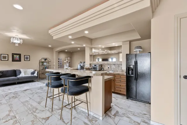 a kitchen with stainless steel appliances granite countertop a refrigerator a sink a stove and oven