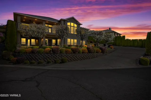an aerial view of residential houses with outdoor space and trees
