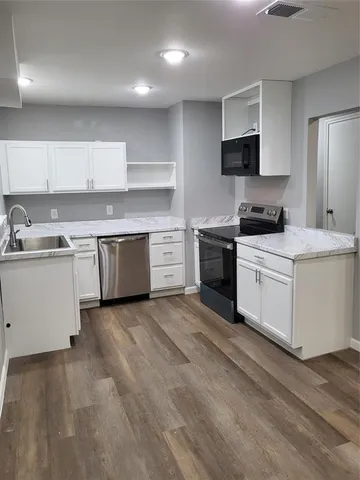 a kitchen with a stove top oven sink and cabinets