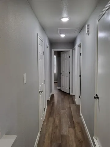 a view of a hallway with wooden floor