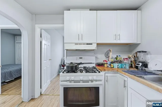 a kitchen with a stove and white cabinets
