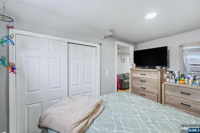 a bedroom with a bed and flat screen tv