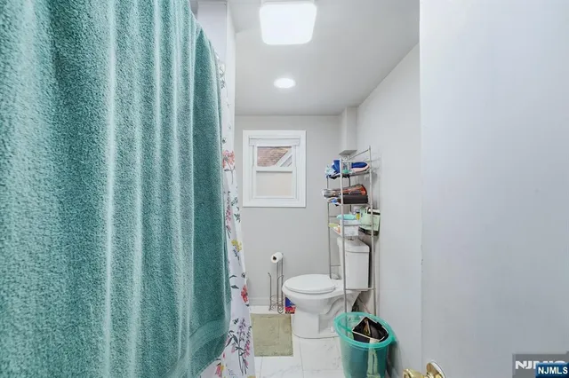 a white toilet sitting next to a bathroom sink and vanity