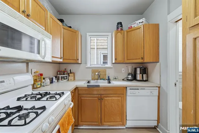 a kitchen with stainless steel appliances a stove a sink and cabinets