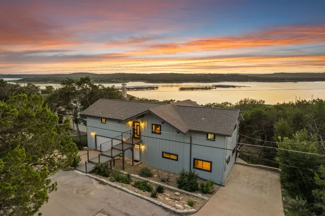 an aerial view of a house with a yard wooden table and chairs