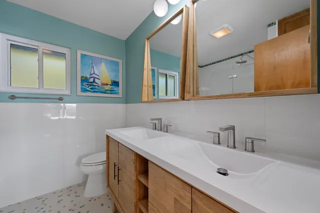 a bathroom with a sink a toilet and mirror