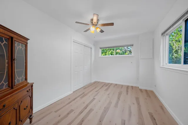 a view of empty room with window and ceiling fan