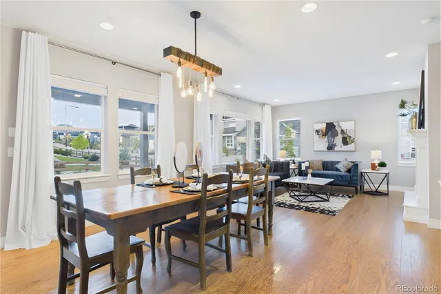 a view of a dining room and livingroom with furniture wooden floor a chandelier