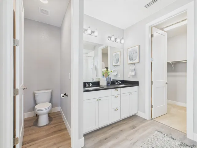 a spacious bathroom with a granite countertop sink toilet a large mirror a shower and a bathtub