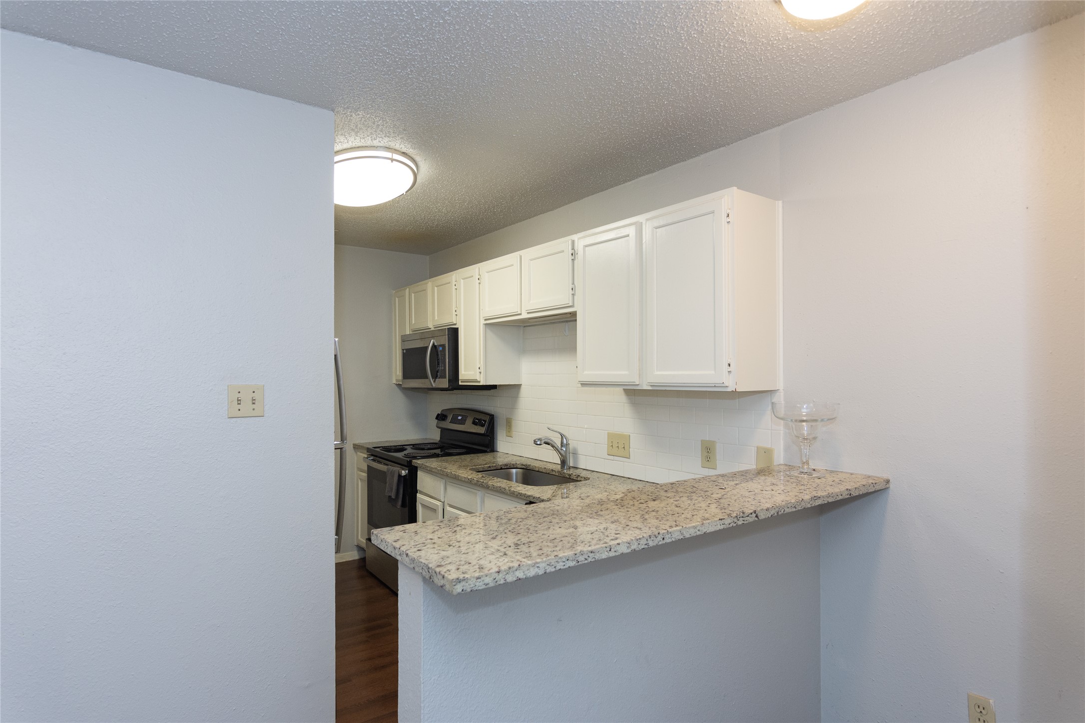 3115 Helms Street, Unit 106 Austin, TX 78705 - Photo 5 of 7 A well-appointed kitchen offers ample counter space and modern appliances.