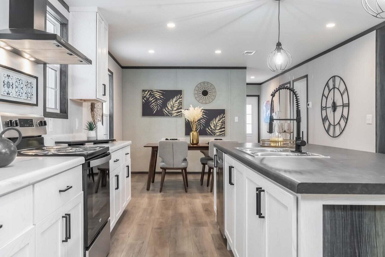 19520 260th Street Okeechobee, FL 34972 - Photo 6 of 17 a very nice looking kitchen with granite countertop a stove a sink a dining table and chairs