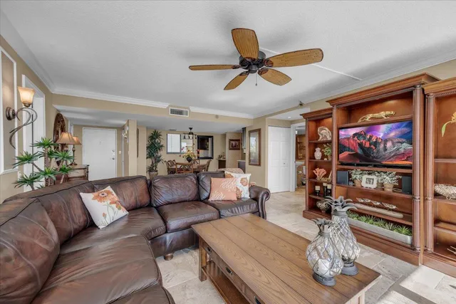a living room with furniture and a flat screen tv with kitchen view