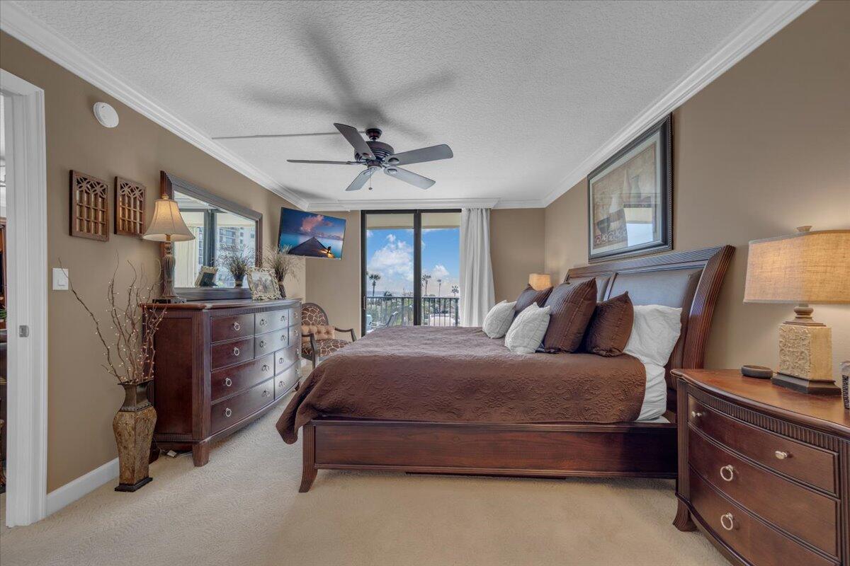 200 Ocean Trail Way, Unit 108 Jupiter, FL 33477 - Photo 15 of 38 a bedroom with a bed and a chandelier