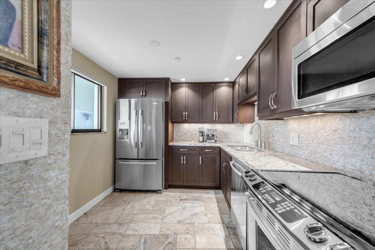 200 Ocean Trail Way, Unit 108 Jupiter, FL 33477 - Photo 5 of 38 a kitchen with a stove microwave and refrigerator