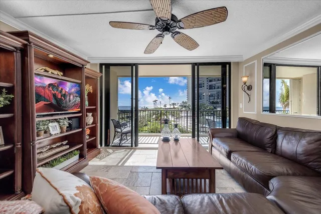 a living room with furniture a floor to ceiling window and a flat screen tv