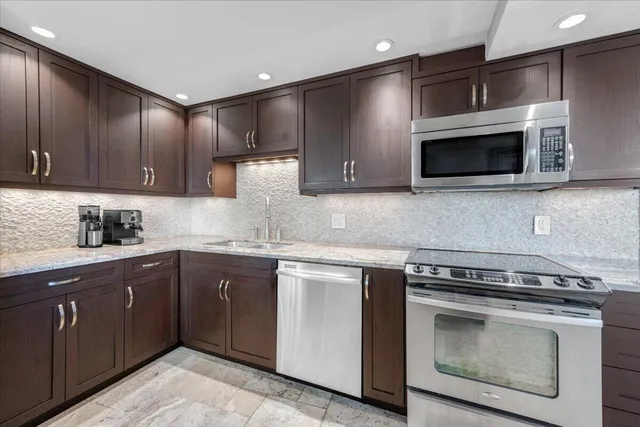 a kitchen with stainless steel appliances a stove microwave and cabinets