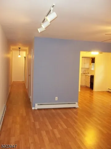 a view of entryway with wooden floor and cabinet