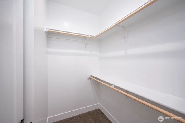 a view of a hallway with wooden floor and closet