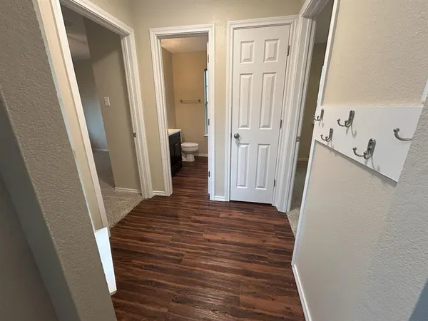 a view of a hallway with wooden floor and staircase