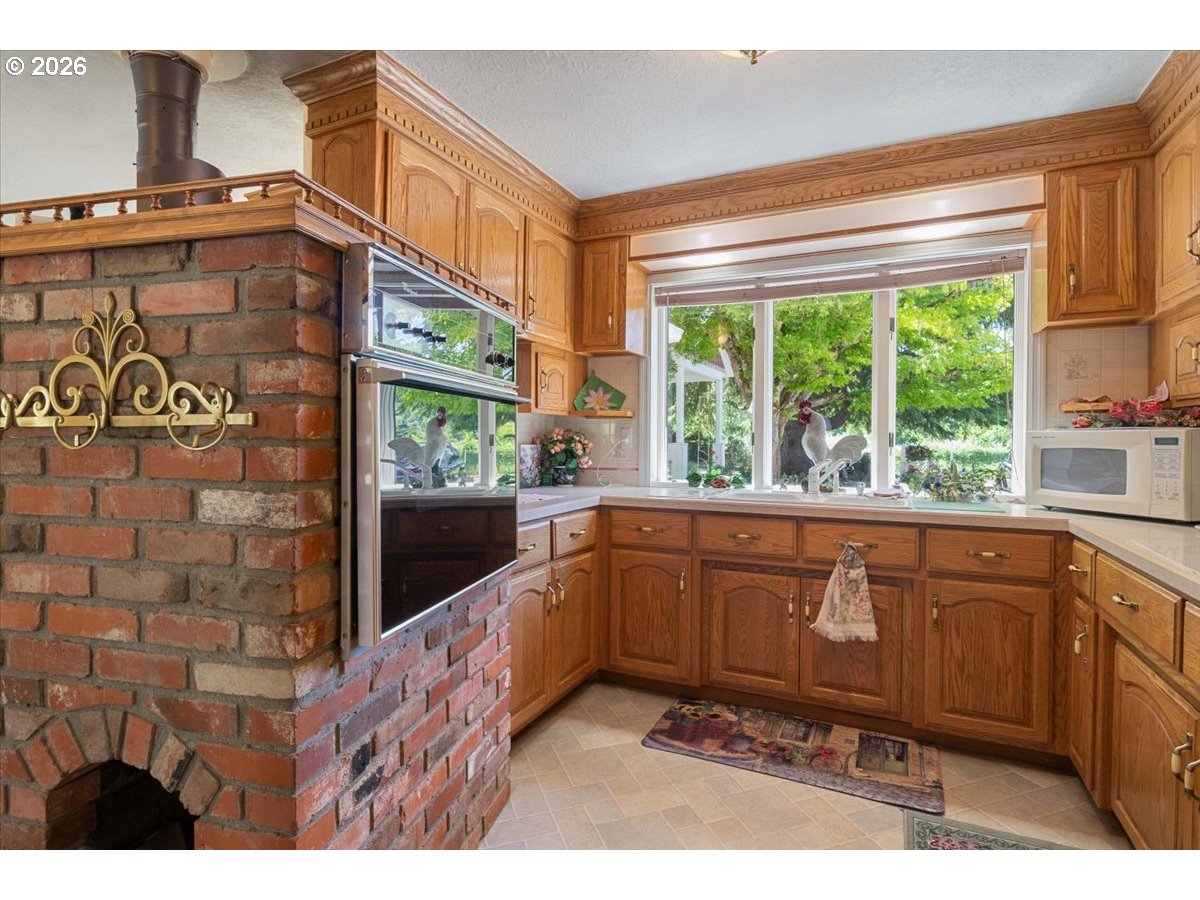 1300 Fair Oaks Road Oakland, OR 97462 - Photo 20 of 48 a kitchen with stainless steel appliances granite countertop a stove a sink and a microwave