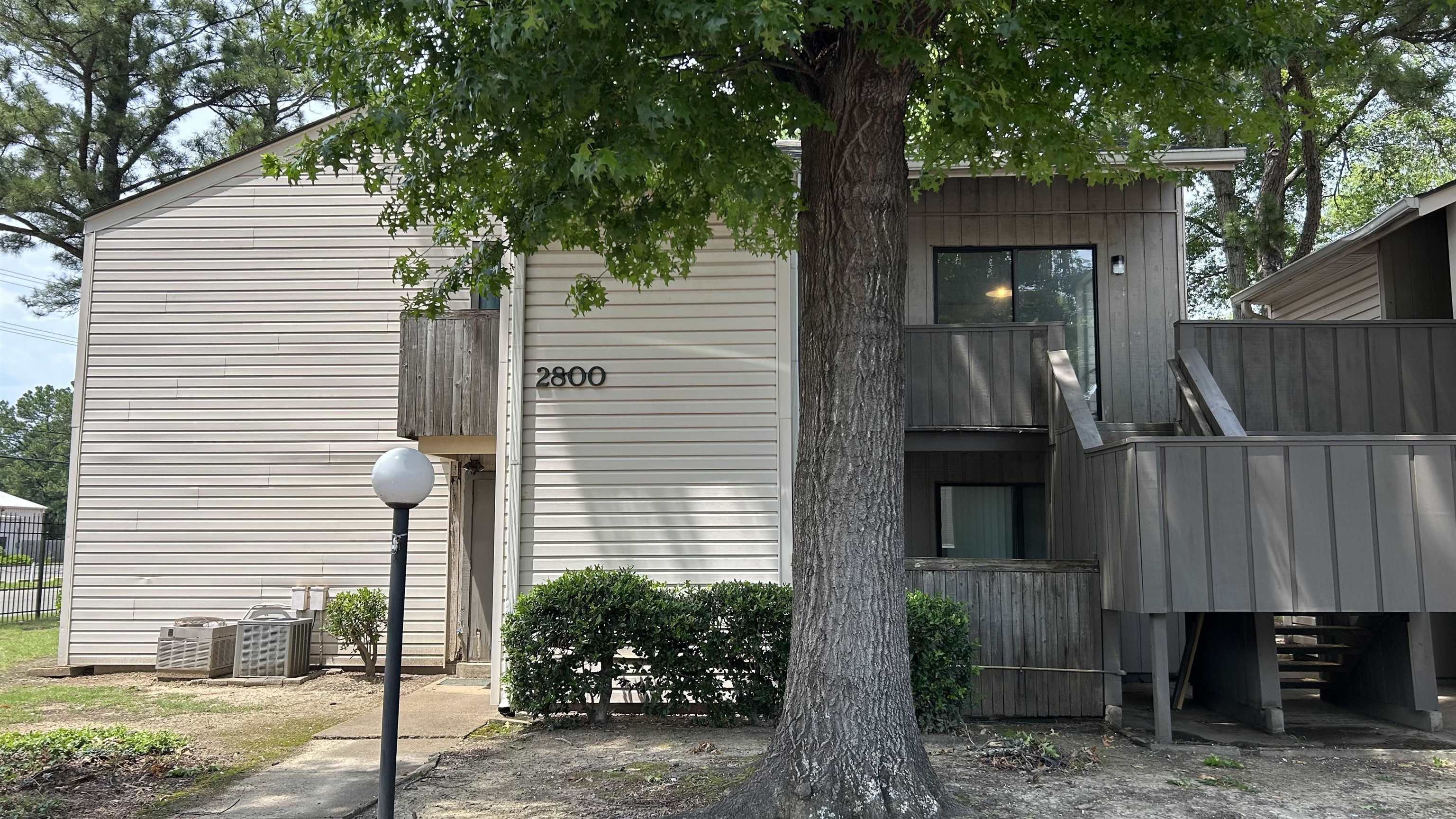 Two-story exterior with vinyl siding and wood-paneled accents