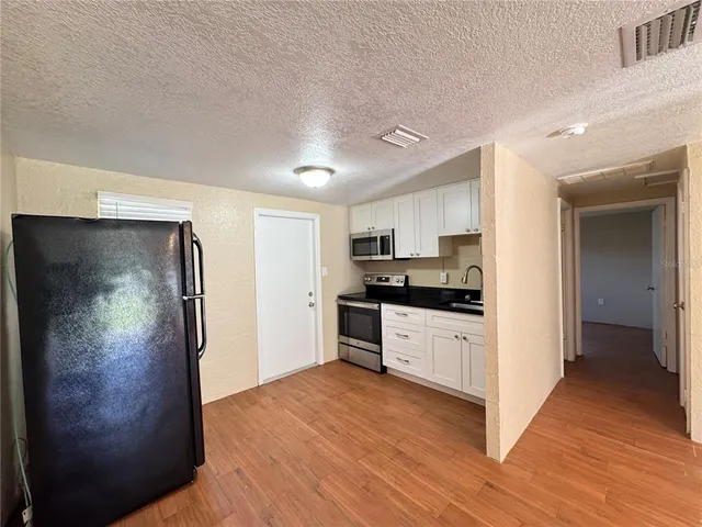 a kitchen with white cabinets and stainless steel appliances