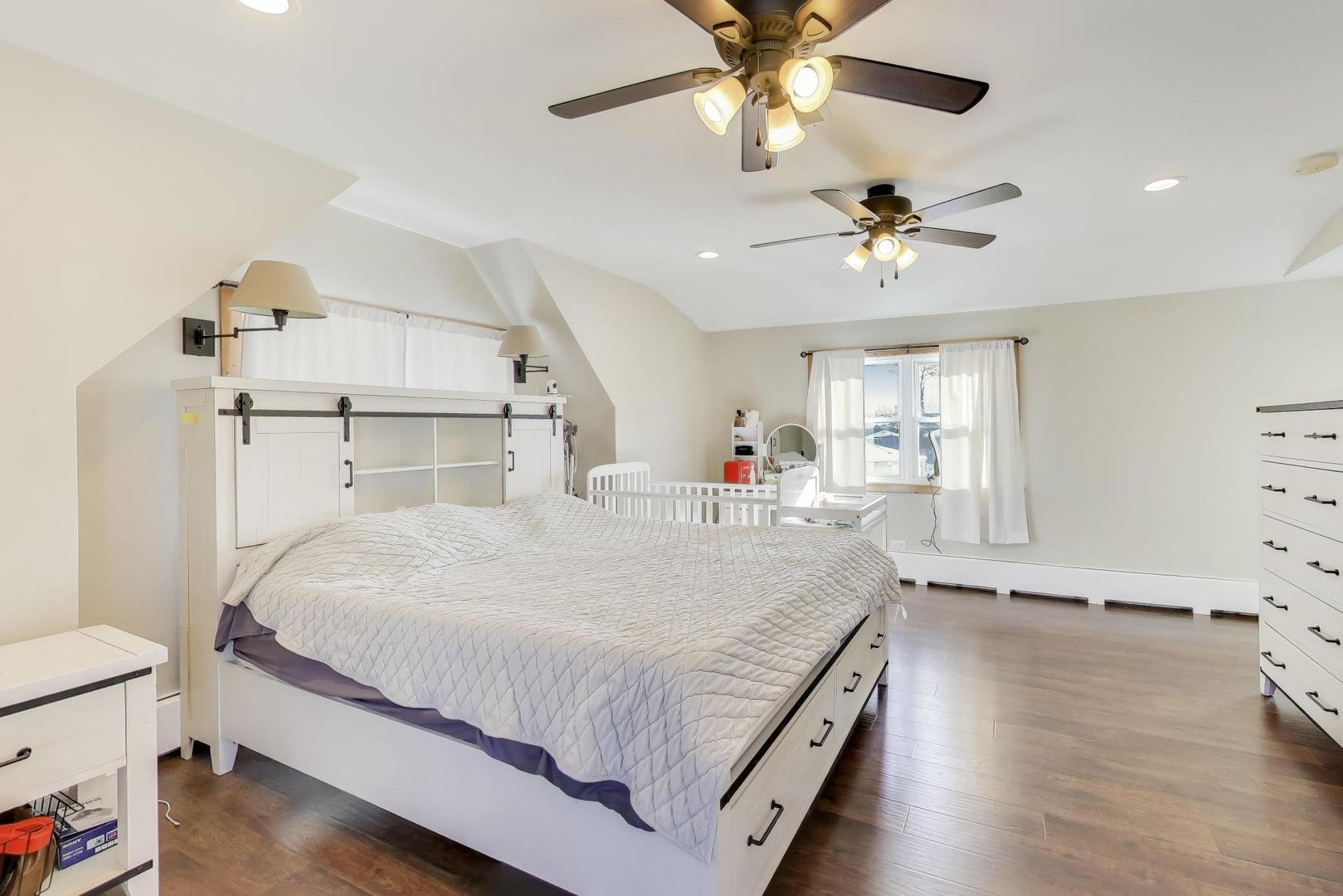 29 Iowa Avenue Addison, IL 60101 - Photo 16 of 31 a spacious bedroom with a bed and a chandelier