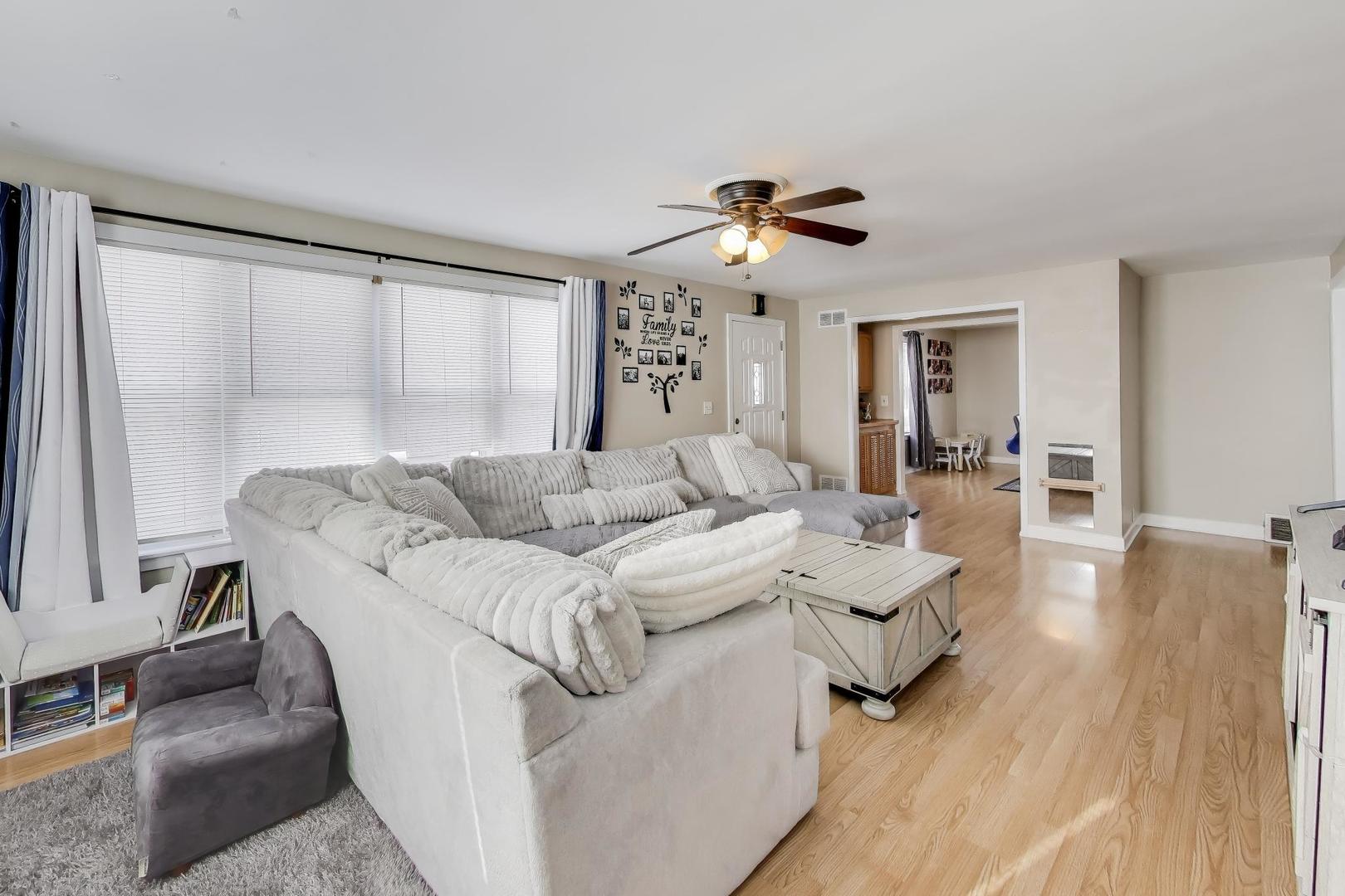 29 Iowa Avenue Addison, IL 60101 - Photo 3 of 31 a living room with couches and a dining table with wooden floor