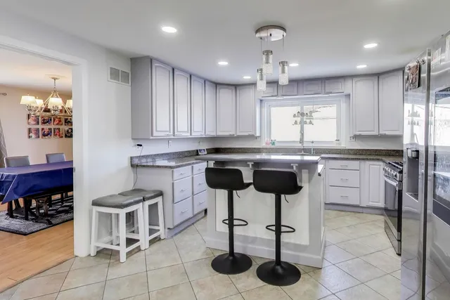 a kitchen with stainless steel appliances granite countertop a stove a sink a refrigerator and a refrigerator