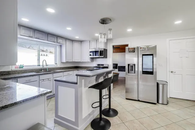 a kitchen with granite countertop white cabinets and sink