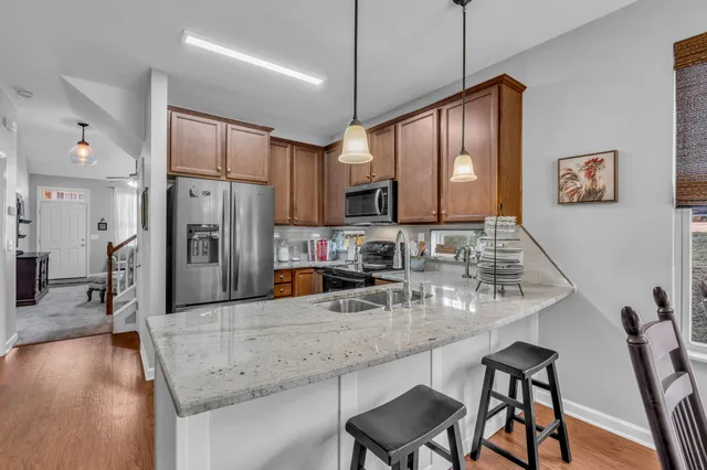 a kitchen with stainless steel appliances granite countertop a stove refrigerator and cabinets