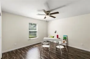 a workspace with furniture a ceiling fan and wooden floor