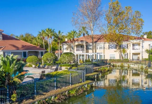a view of swimming pool with outdoor seating and trees in the background