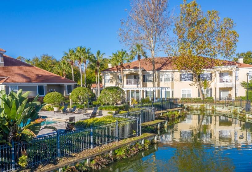 a view of swimming pool with outdoor seating and trees in the background