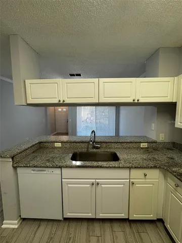 a kitchen with granite countertop a sink and cabinets