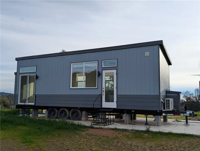 a front view of building with river and trees in the background