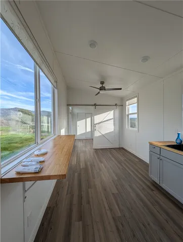 a view of a kitchen with wooden floor and a window