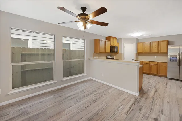 a kitchen with stainless steel appliances granite countertop a stove top oven a sink and dishwasher with wooden floor