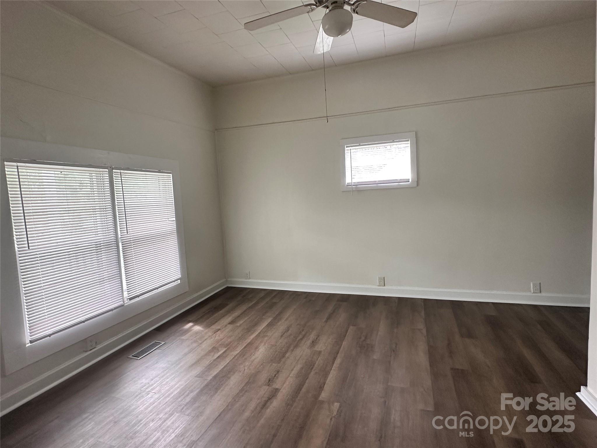 103 Fairview Street Clover, SC 29710 - Photo 11 of 24 an empty room with wooden floor and windows