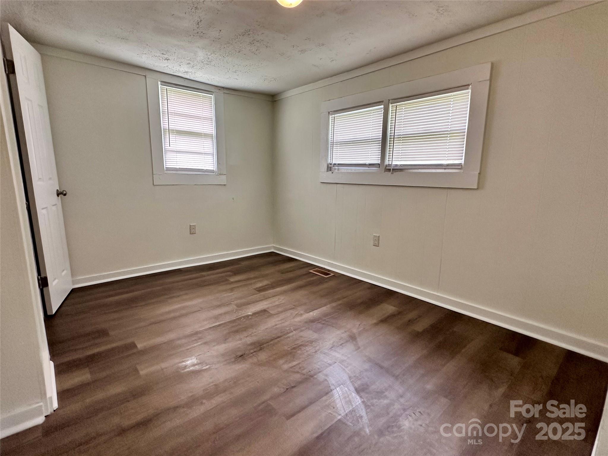 103 Fairview Street Clover, SC 29710 - Photo 21 of 24 an empty room with wooden floor and windows
