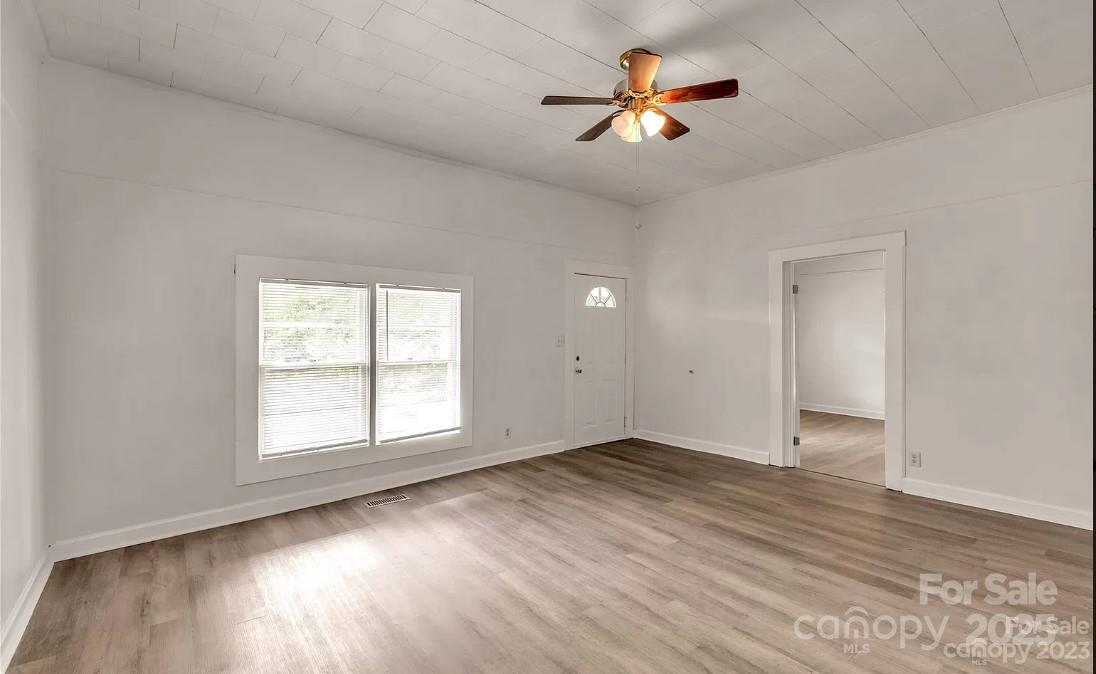 103 Fairview Street Clover, SC 29710 - Photo 8 of 24 an empty room with wooden floor and chandelier fan