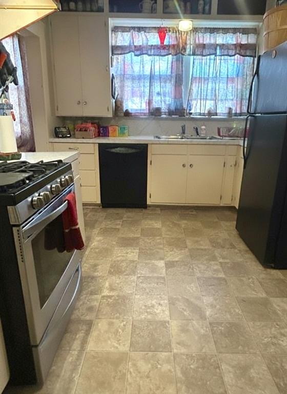 706 Virginia Street Graham, TX 76450 - Photo 5 of 10 a kitchen with a stove a sink and a refrigerator